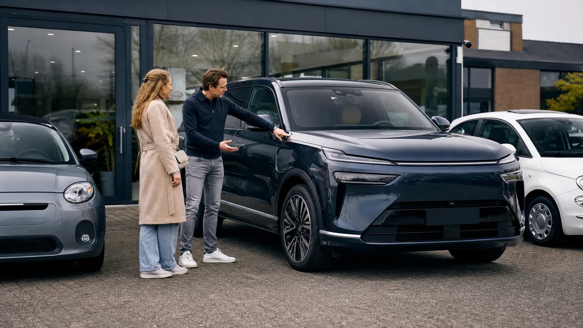 Grote elektrische SUV bij een Nederlandse occasiondealer naast compactere auto’s